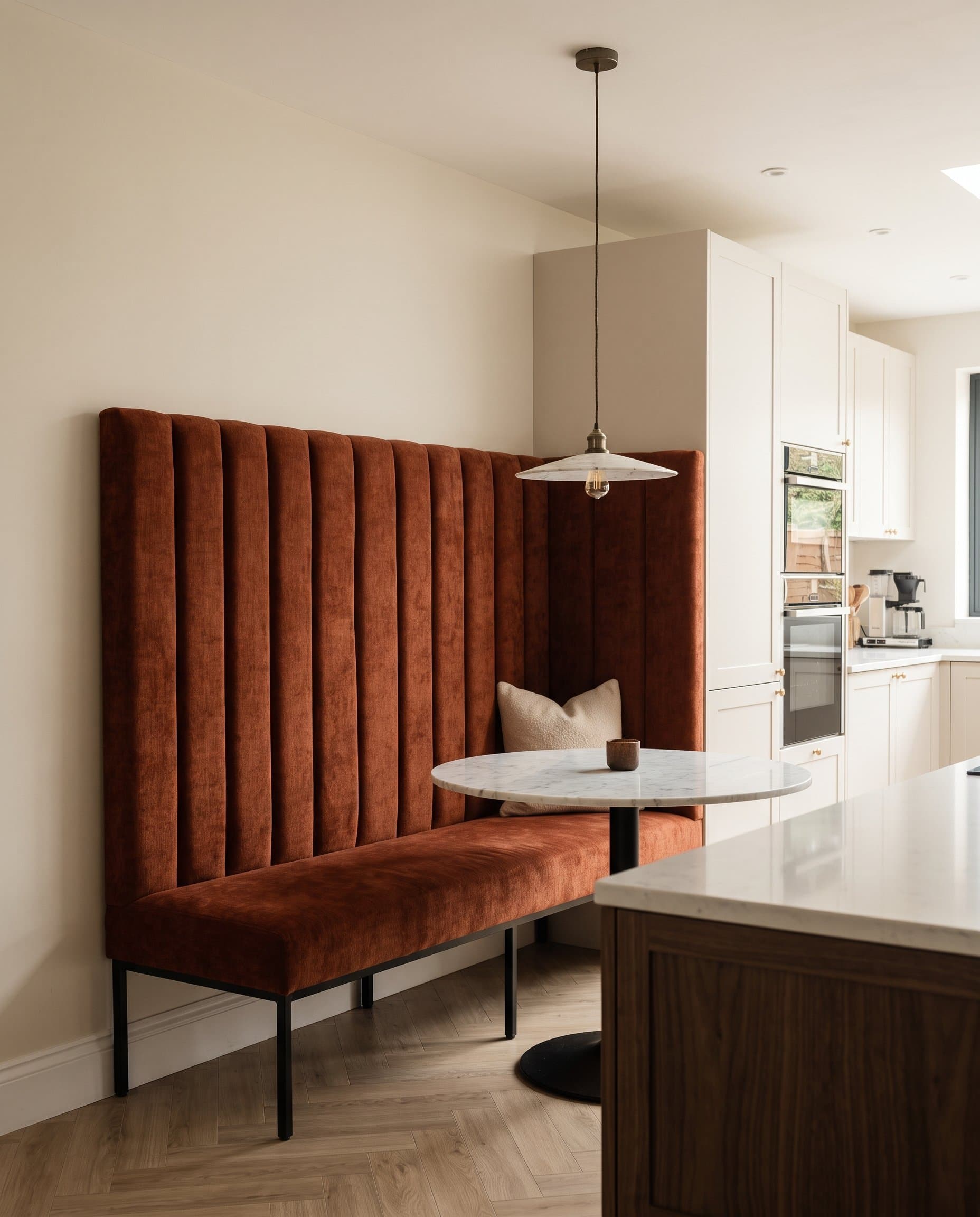 Marine: a tall fluted rust banquette on black steel legs in a kitchen dining nook